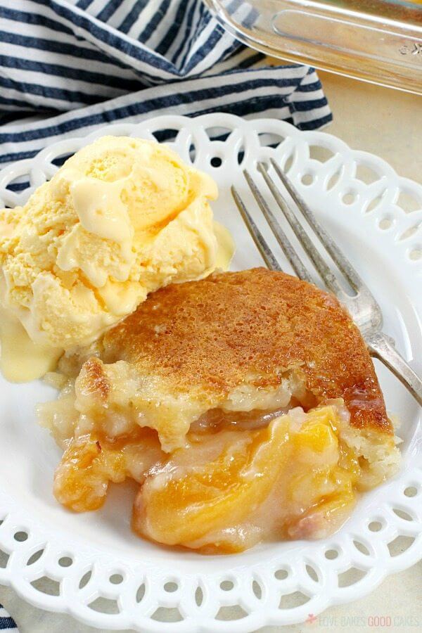 Easy Southern Peach Cobbler en un plato con helado y un tenedor de cerca.