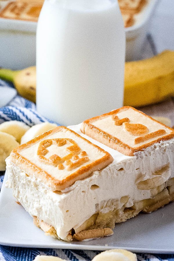 budín de plátano paula deen en un plato con un vaso de leche en segundo plano.