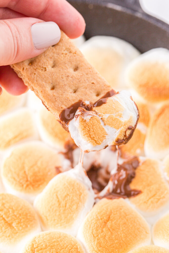 smores dip se recoge de una galleta graham