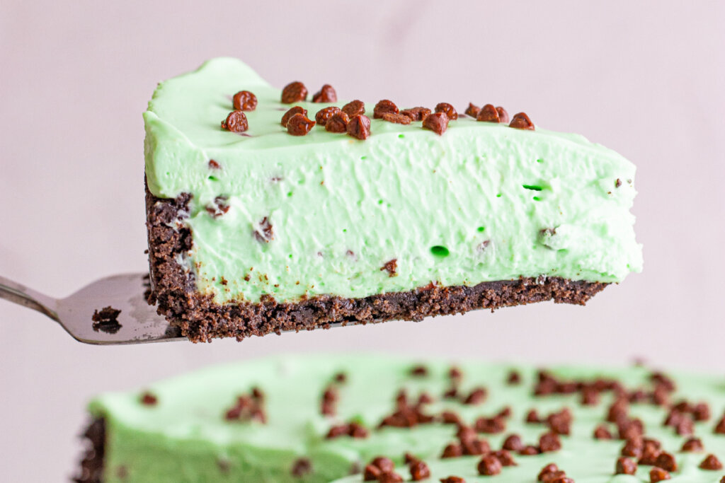 rebanada de tarta de queso con trocitos de chocolate y menta en un utensilio para servir