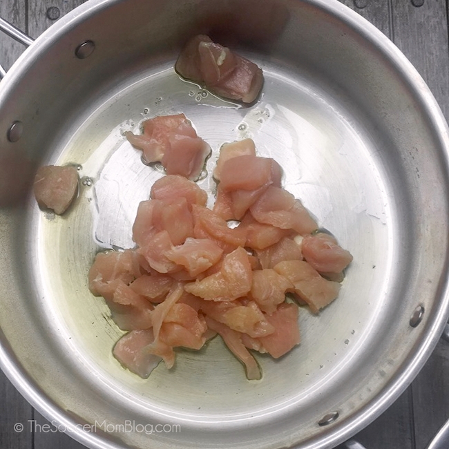 Dorar la pechuga de pollo cruda en cubos en una sartén con el aceite.