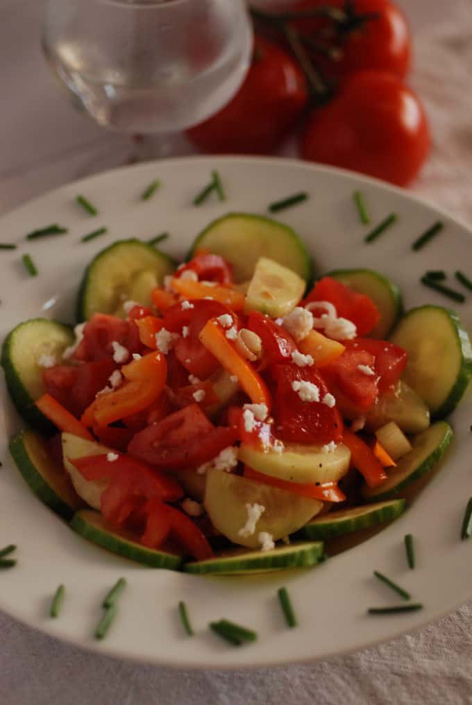 un plato de ensalada serbia con pepino, tomate, chile y queso