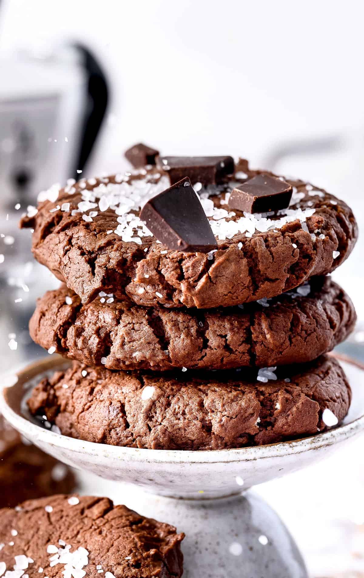 Tres galletas con chispas de chocolate apiladas una encima de la otra con sal sellada y chispas de chocolate encima.