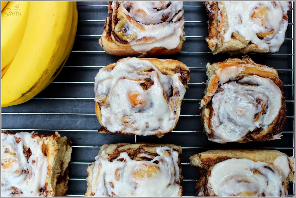 Nutella Banana Cinnamon Rolls en una hoja de refrigeración con plátanos.