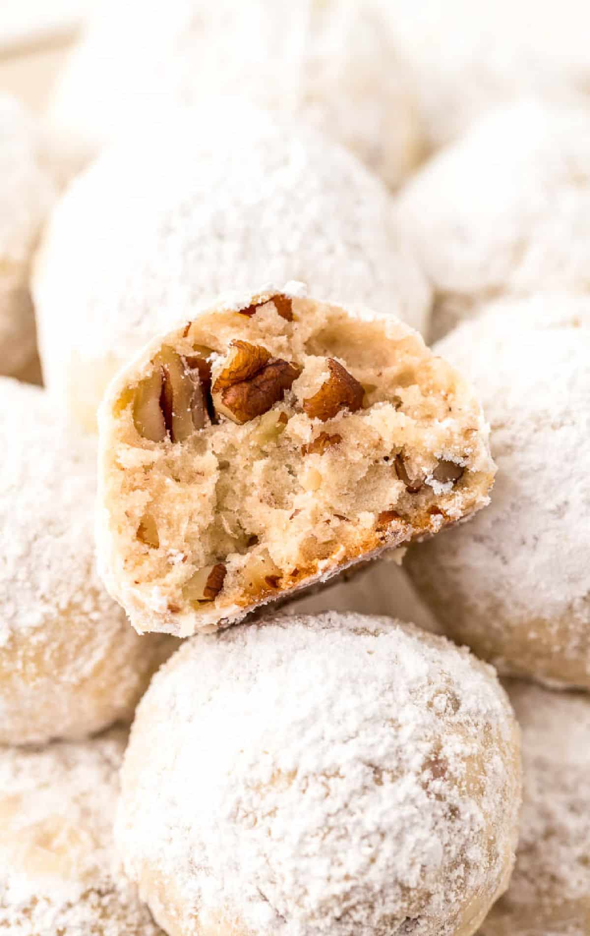 Un primer plano de una galleta medio mordida en un montón de galletas.