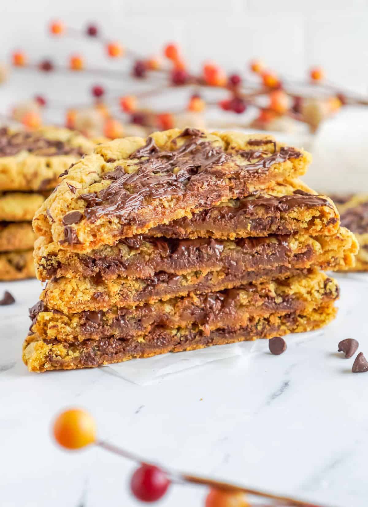 Una pila de galletas de chocolate y calabaza a la mitad con chocolate negro.