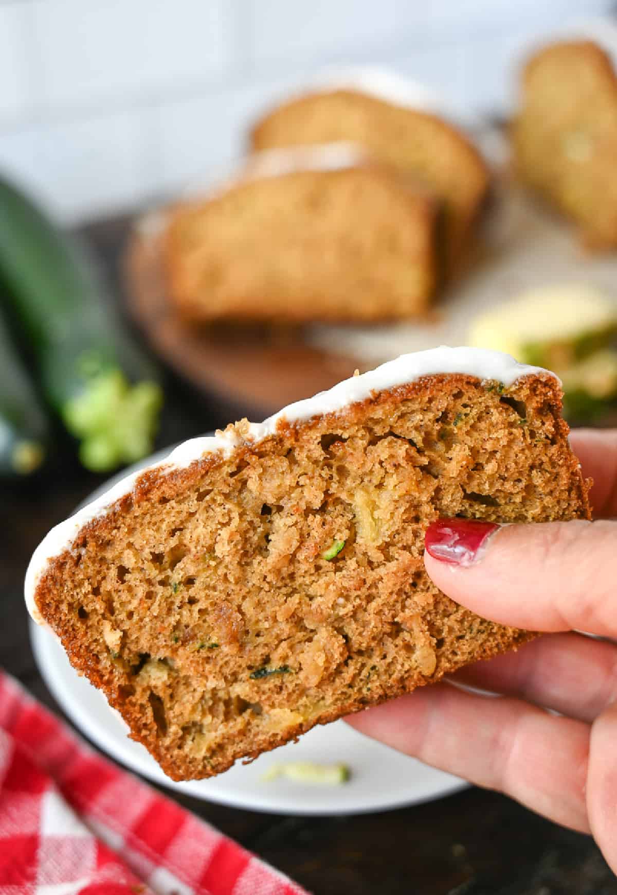 Una rebanada de pan de piña y calabacín en la mano.