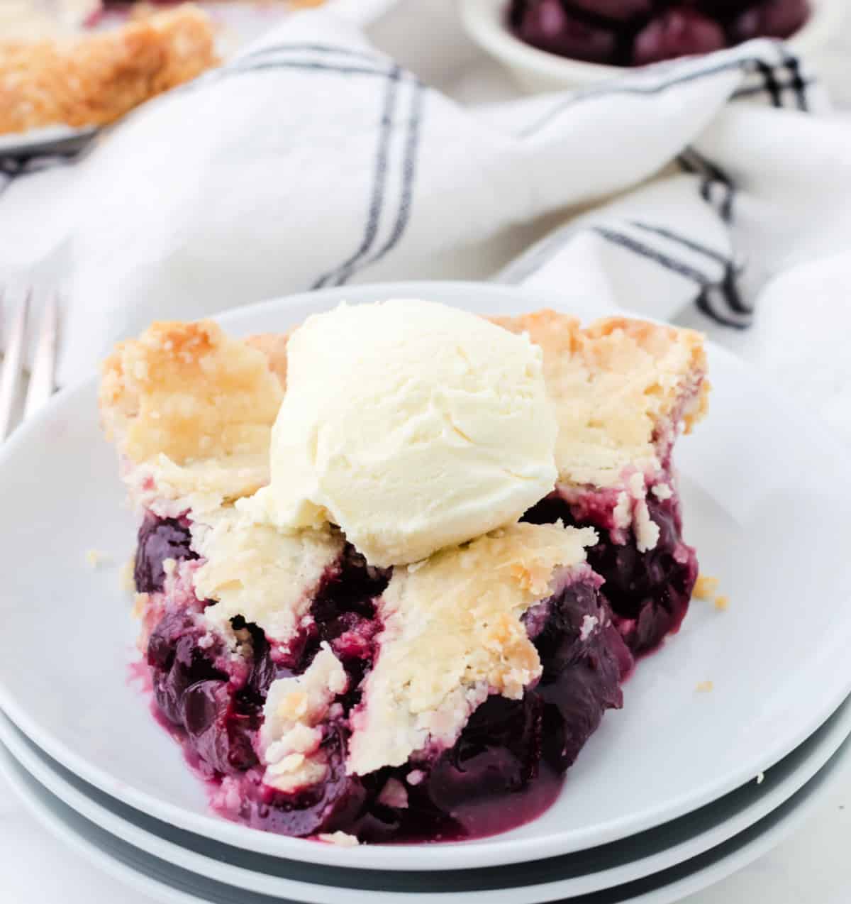 Un pastel de cerezas hace clic en un plato blanco.