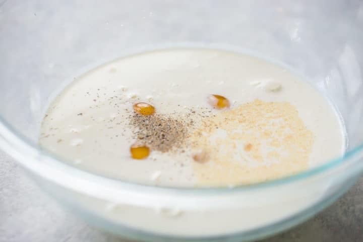 Huevos, crema, leche y especias en un bol.