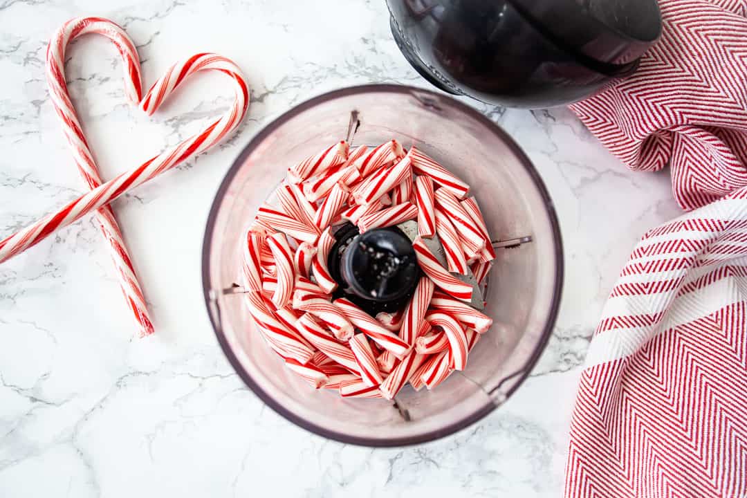 Bastones de caramelo rotos en el recipiente de un pequeño procesador de alimentos.