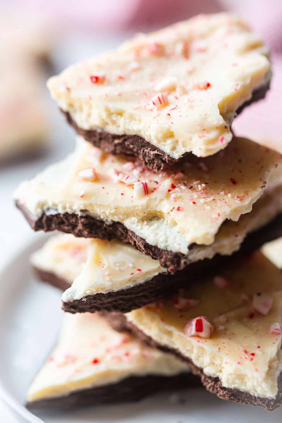 Cáscara de menta Ghirardelli casera, apilada en un plato de porcelana blanca.