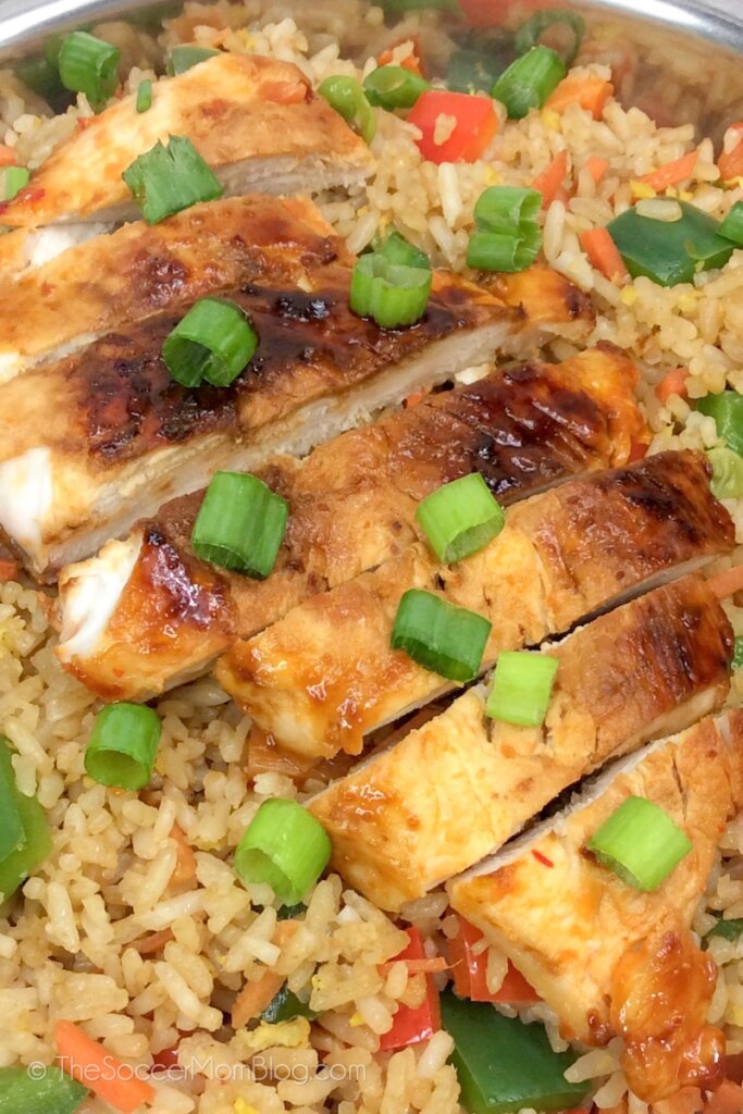 pollo teriyaki glaseado servido sobre una cama de arroz frito con verduras