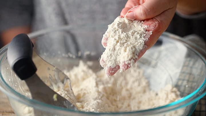 Masa de masa quebrada cruda, con trozos de mantequilla del tamaño de un guisante.