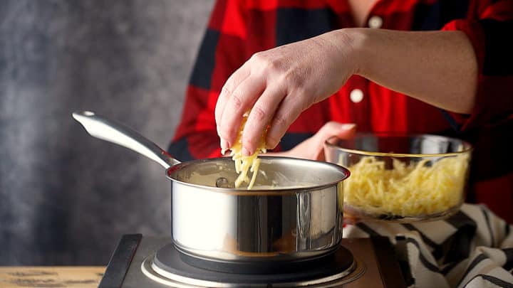 Agregue el queso cheddar rallado a la cerveza.