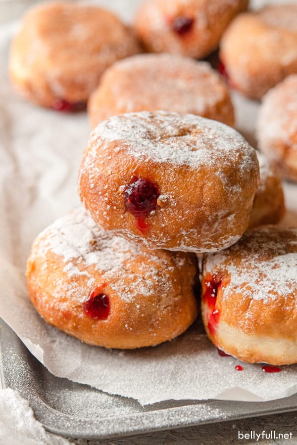 Una pila de tres Sufganiyot Jelly Donuts con un fondo de papel pergamino