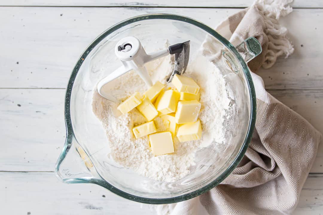 Ingredientes secos de pastel de plátano en un tazón con mantequilla blanda.