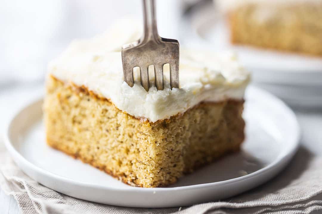 Pastel de plátano con crema agria, cubierto con glaseado de queso crema, con un tenedor de plata vintage.