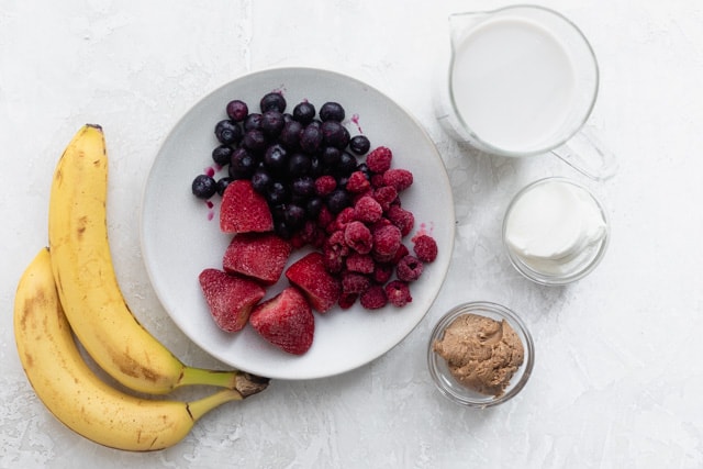 Ingredientes para preparar la receta: plátanos, frutos rojos, leche, yogur griego y mantequilla de almendras