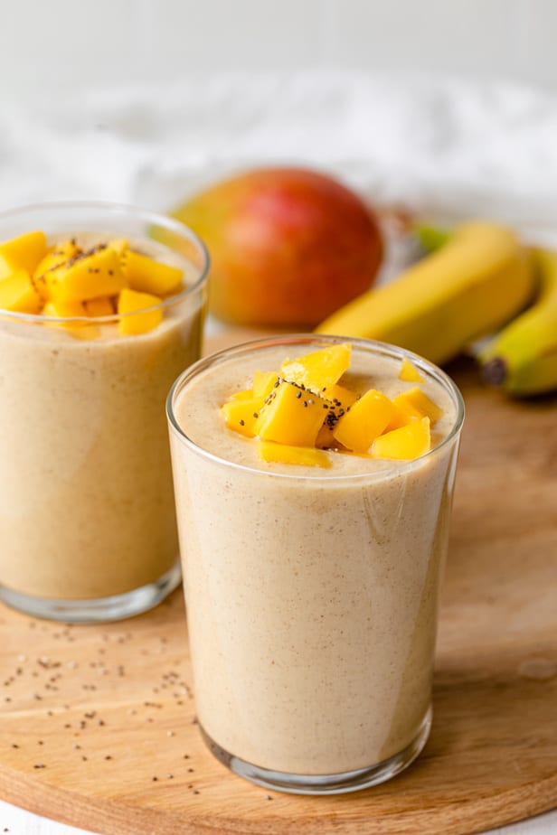 Dos vasos de batidos de mango y plátano