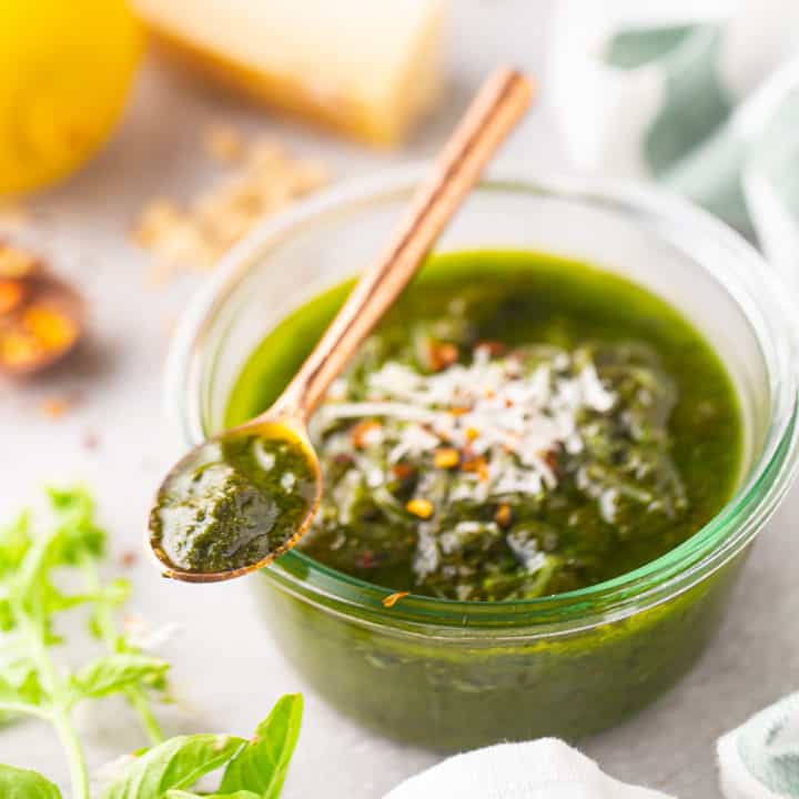 Receta de pesto, preparado y servido en un tarro de cristal poco profundo.